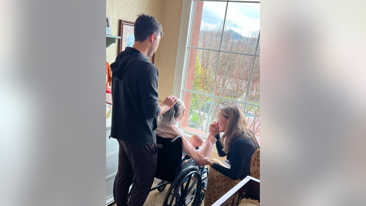 Barbara Rush sitzt mit ihrer Tochter und ihrem Enkel im Rollstuhl und blickt aus dem Fenster.