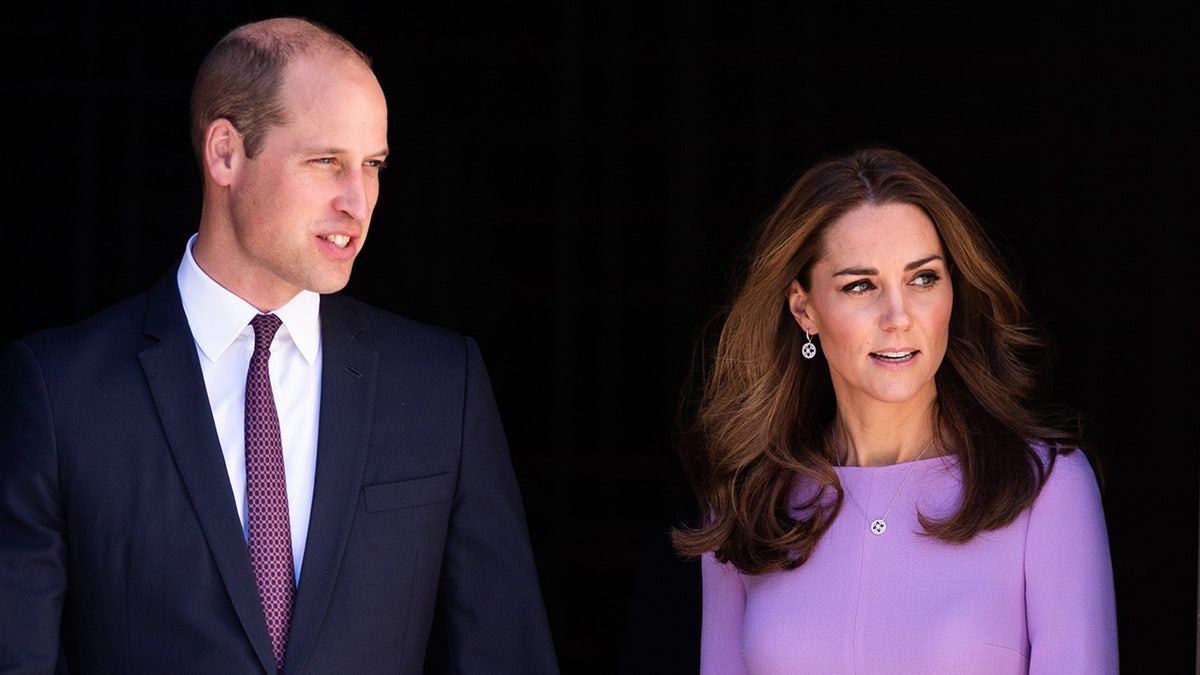 Prinz William geht neben Kate Middleton, die ein lila Kleid trägt
