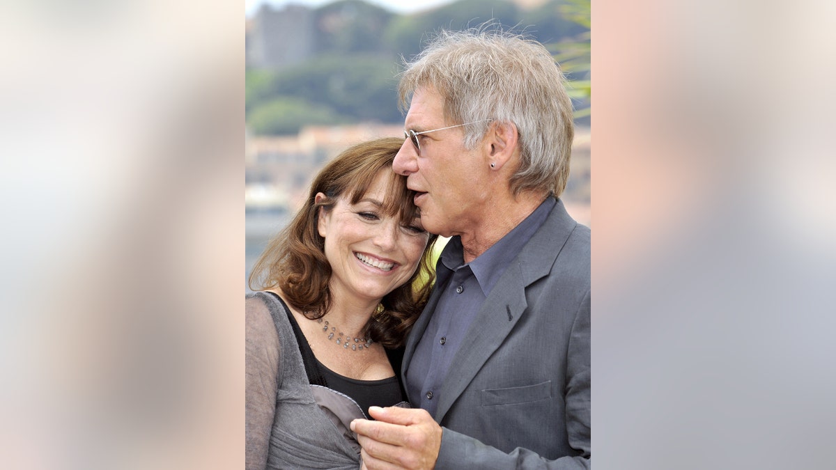 Karen Allen wird von Harrison Ford umarmt