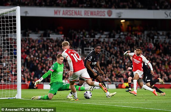 LONDON, ENGLAND - APRIL 03: Emile Smith Rowe of Arsenal passes the ball to teammate Reiss Nelson (obscured) ahead of their team's second goal, an own goal scored by Daiki Hashioka of Luton Town (obscured) during the Premier League match between Arsenal FC and Luton Town at Emirates Stadium on April 03, 2024 in London, England. (Photo by David Price/Arsenal FC via Getty Images)