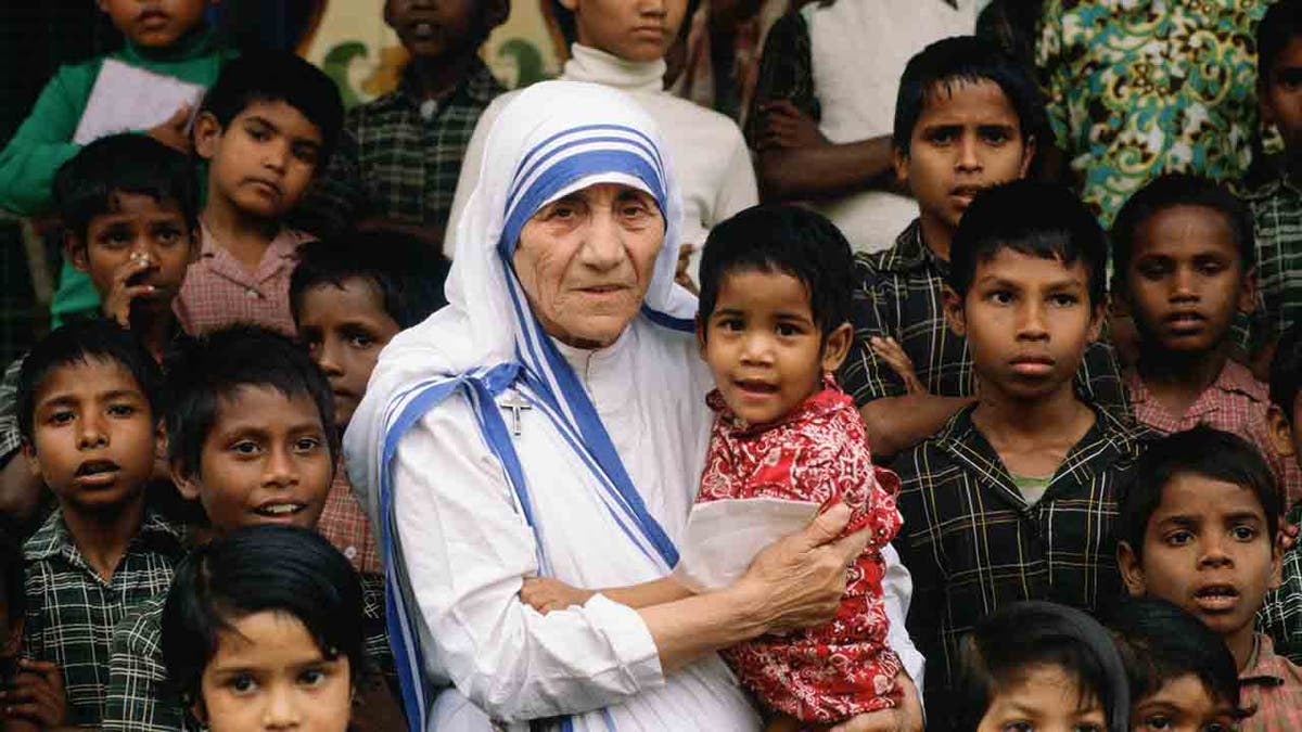 Mutter Teresa umgeben von Kindern in Kalkutta