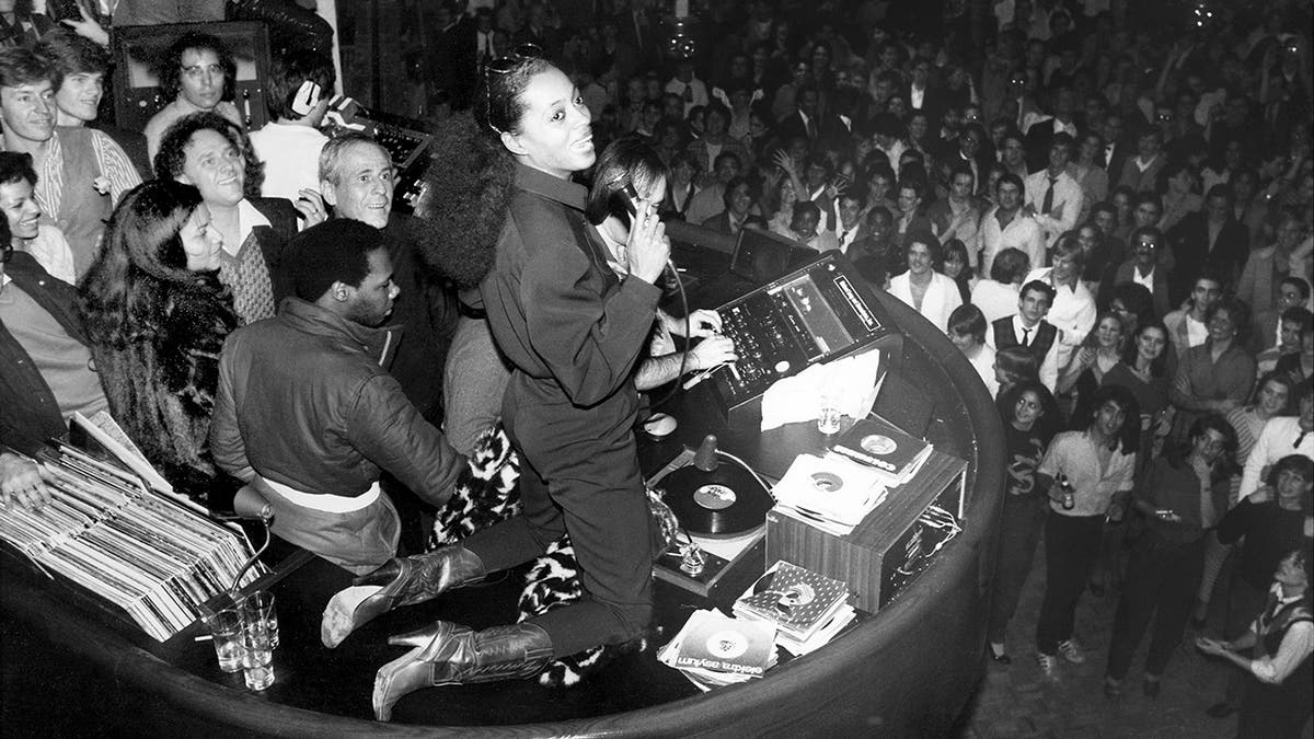 Schwarz-Weiß-Foto von Diana Ross mit einer Menschenmenge unter ihr im Studio 54