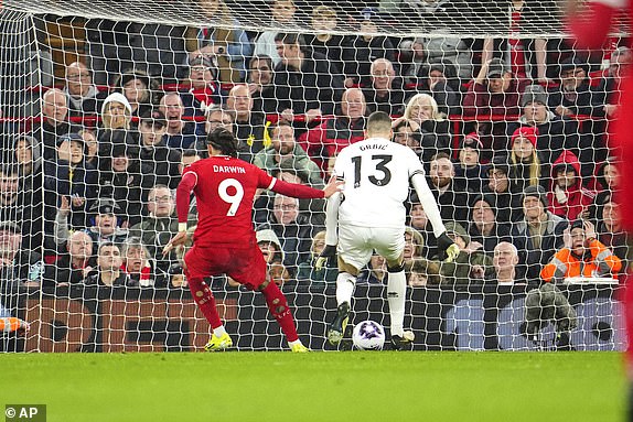Liverpool's Darwin Nunez, left, scores his side's opening goal during the English Premier League soccer match between Liverpool and Sheffield United at the Anfield stadium in Liverpool, England, Thursday, Apr. 4, 2024. (AP Photo/Jon Super)