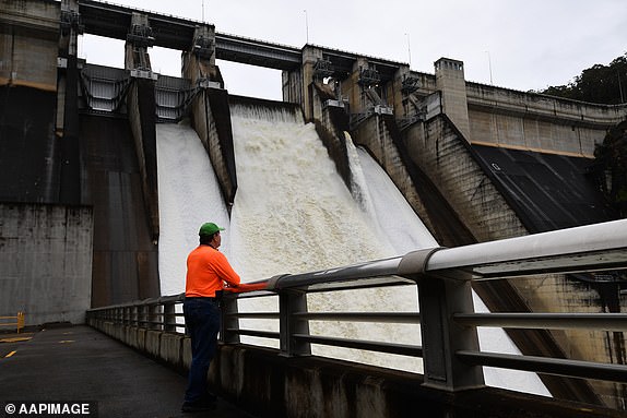 A Water NSW worker is seen monitoriong the spillway outflow of Warragamba Dam, in Warragamba, in South West Sydney, Saturday, November 27, 2021. Sydney's Warragamba Dam spillway outflow could peak at approximately 60-80 gigalitres per day, as the flood crisis continues across NSW, with a month of heavy rainfall coming to a head. (AAP Image/Dan Himbrechts) NO ARCHIVING