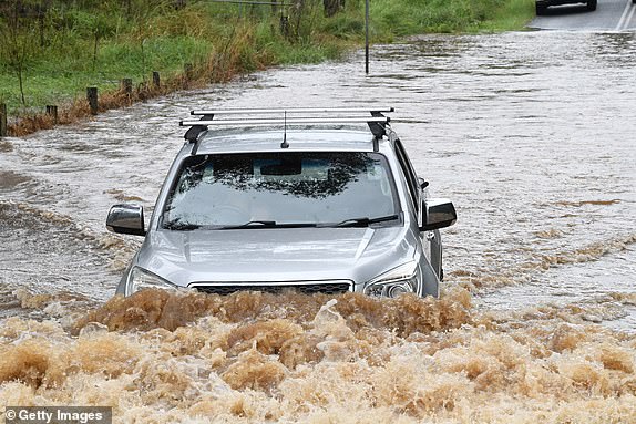 BYRON BAY, AUSTRALIA - APRIL 04: A vehicle attempts to drive through floodwater in the village of Tintenbar on April 04, 2024 in Byron Bay, Australia. A spell of wet weather arrived across coastal NSW on Thursday, bringing heavy rain and elevated flood risk, from the north of the state to Sydney. (Photo by James D. Morgan/Getty Images) *** BESTPIX ***