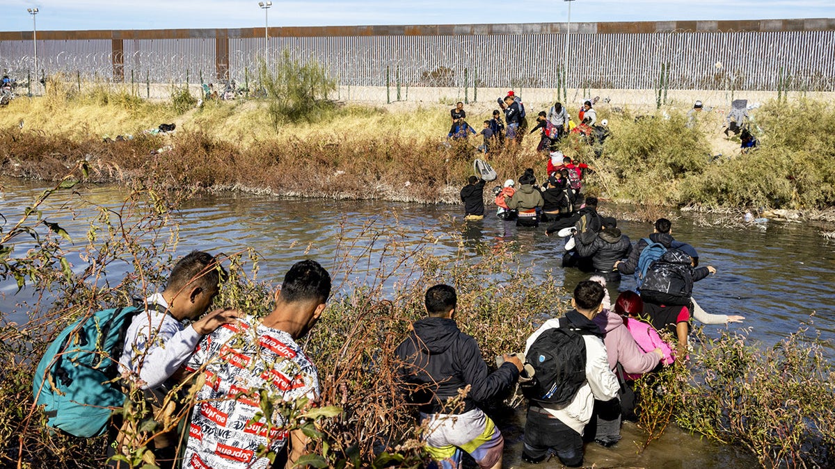 Hunderte Migranten, überwiegend aus Venezuela, überqueren am 5. Dezember 2023 in Ciudad Juárez, Mexiko, den Rio Grande mit der Absicht, humanitäres Asyl zu beantragen, indem sie die Grenze zwischen Mexiko und den Vereinigten Staaten überqueren. Als sie den Rio Grande erreichten, stießen sie auf eine Barriere Stacheldraht und Soldaten der texanischen Nationalgarde verbieten ihnen die Überquerung des Flusses.  Dennoch fanden viele einen Weg, den Fluss zu überqueren, und stellten eine Schlange vor einem Tor in der Mauer mit der Nummer 36 auf, in der Hoffnung, von der Grenzpolizei bearbeitet zu werden und anschließend humanitäres Asyl zu beantragen.  (Foto von David Peinado/Anadolu über Getty Images)