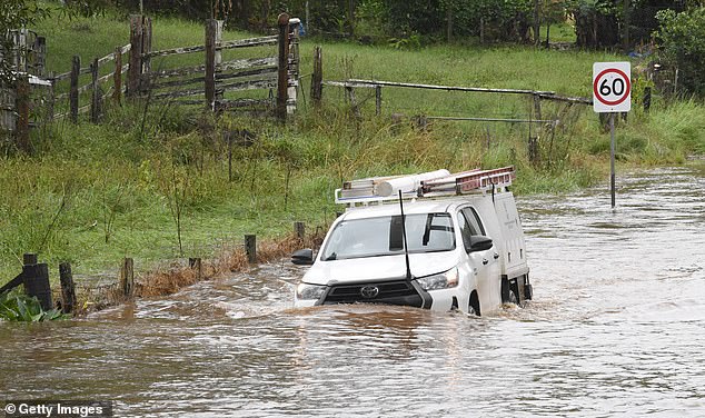 Ein Fahrzeug versucht am 4. April 2024 in Byron Bay, Australien, durch Hochwasser im Dorf Tintenbar zu fahren