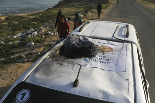 Palästinenser inspizieren ein Fahrzeug mit dem Logo der World Central Kitchen, das durch einen israelischen Luftangriff in Deir al Balah, Gazastreifen, am 2. April 2024 zerstört wurde. (AP Photo/Ismael Abu Dayyah)