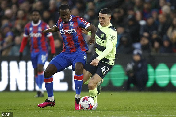 Manchester City's Phil Foden, right, challenges for the ball with Crystal Palace's Tyrick Mitchell during the English Premier League soccer match between Crystal Palace and Manchester City at Selhurst Park stadium, in London, Saturday, March 11, 2023. (AP Photo/David Cliff)