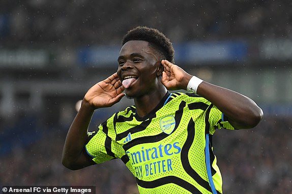 BRIGHTON, ENGLAND - APRIL 06: Bukayo Saka of Arsenal celebrates scoring his team's first goal from the penalty spot during the Premier League match between Brighton & Hove Albion and Arsenal FC at American Express Community Stadium on April 06, 2024 in Brighton, England. (Photo by David Price/Arsenal FC via Getty Images)
