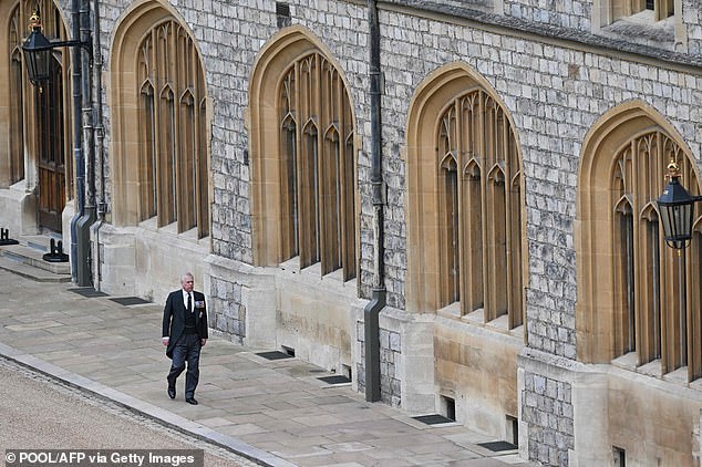 Prince Andrew strikes a solitary figure in his black morning suit as he walks inside the grounds of Windsor Castle ahead of his mother's emotional send-off