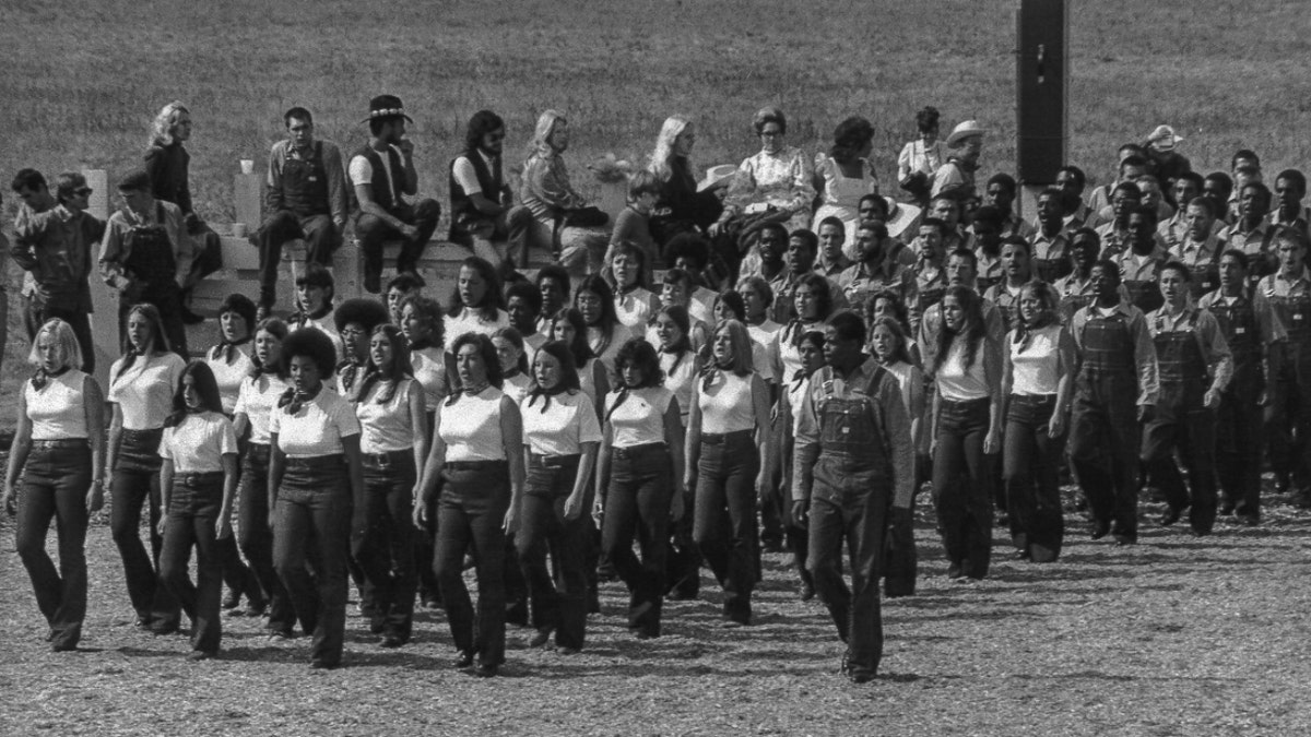 Eine Gruppe von Synanon-Mitgliedern in denselben Uniformen marschiert in geraden Reihen