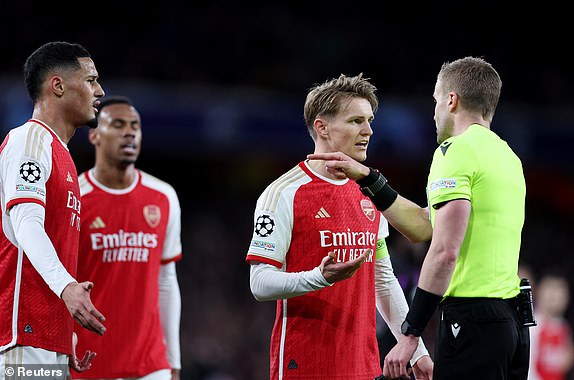 Soccer Football - Champions League - Quarter Final - First Leg - Arsenal v Bayern Munich - Emirates Stadium, London, Britain - April 9, 2024 Arsenal's William Saliba and Martin Odegaard remonstrate with referee Glenn Nyberg after a penalty is awarded to Bayern Munich REUTERS/David Klein