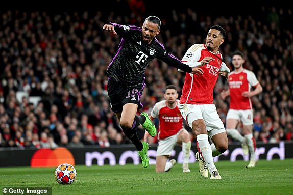 LONDON, ENGLAND - APRIL 09: Leroy Sane of Bayern Munich is tackled by William Saliba of Arsenal leading to a penalty decision for Bayern Munich during the UEFA Champions League quarter-final first leg match between Arsenal FC and FC Bayern MÃ¼nchen at Emirates Stadium on April 09, 2024 in London, England. (Photo by Shaun Botterill/Getty Images)