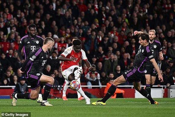 LONDON, ENGLAND - APRIL 09: Bukayo Saka of Arsenal scores his team's first goal under pressure from Eric Dier of Bayern Munich during the UEFA Champions League quarter-final first leg match between Arsenal FC and FC Bayern MÃ¼nchen at Emirates Stadium on April 09, 2024 in London, England. (Photo by Mike Hewitt/Getty Images)
