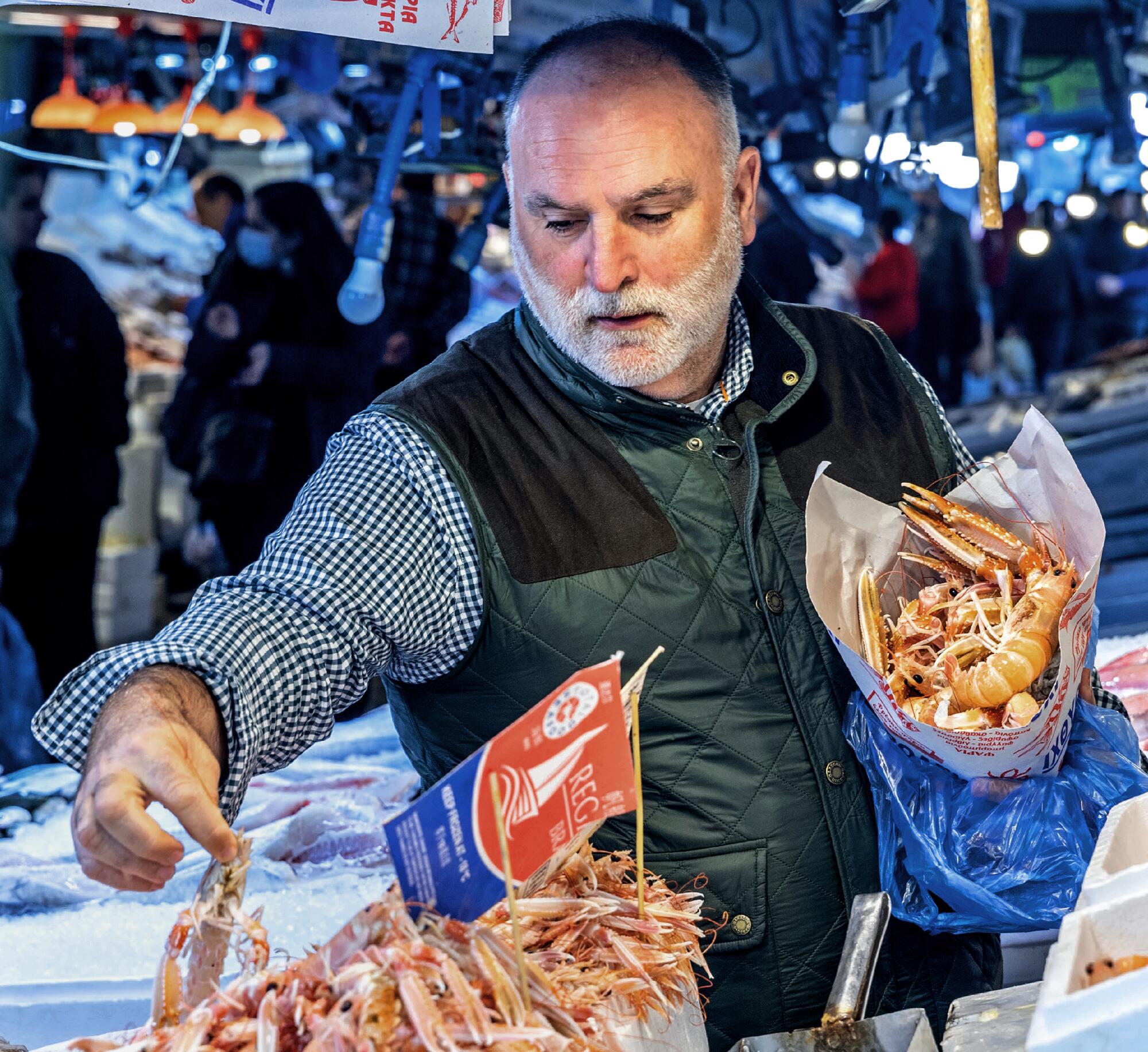 Chefkoch José Andrés besucht den Athener Markt in Griechenland.  An einem Imbissstand hält er ein Bündel Meeresfrüchte unter einem Arm.