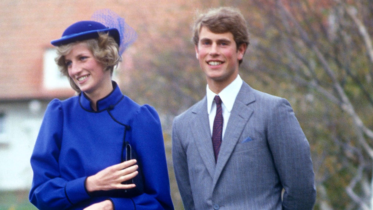 Prinzessin Diana in einem leuchtend blauen Kleid lächelt neben Prinz Edward in Anzug und Krawatte