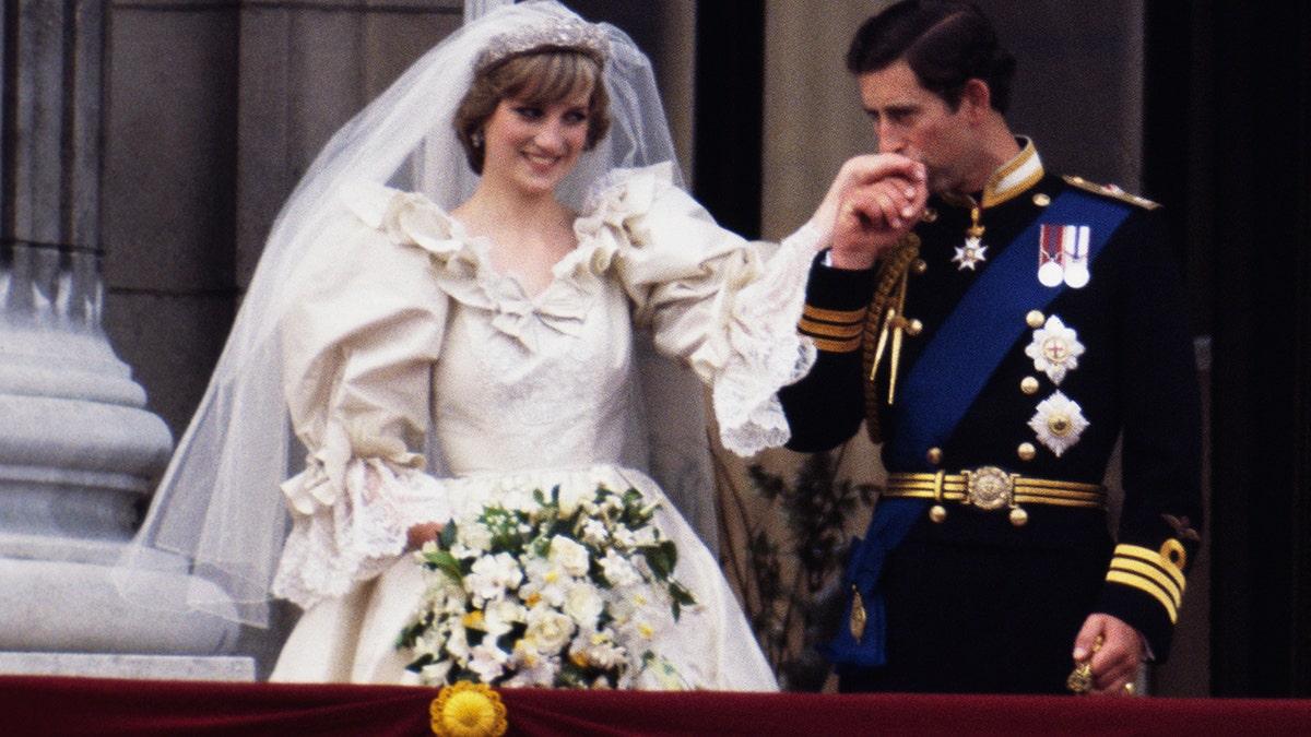 Prinzessin Diana in einem Brautkleid lässt sich von ihrem Bräutigam Prinz Charles die Hand küssen