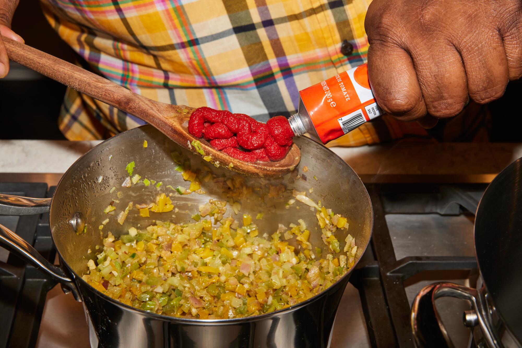 Chefkoch Michael Twitty fügt seinem Gumbo Tomatenmark hinzu.