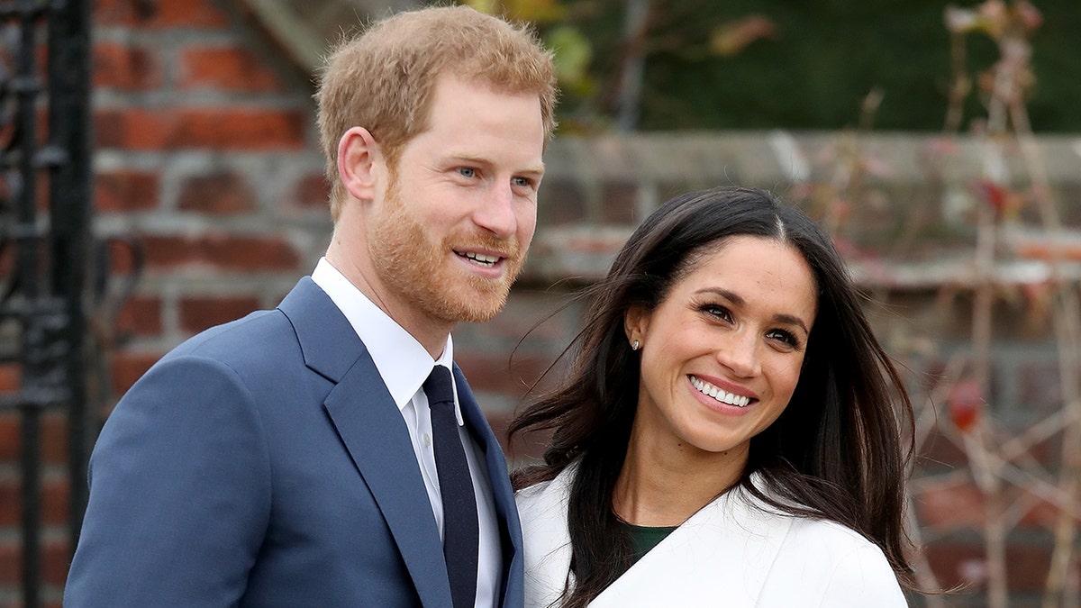 Prinz Harry und Meghan Markle lächeln als hochrangige Royals