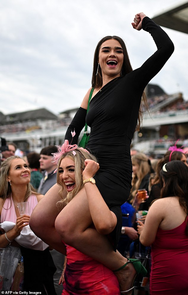 One woman is pictured on her friend's shoulders as they celebrated at Aintree today