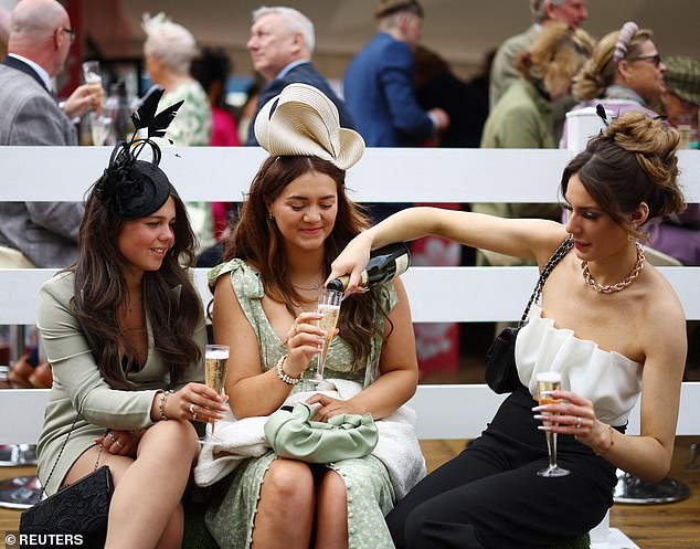 A trio of revellers are pictured topping up their champagne as they begin a day full of fashion-filled fun