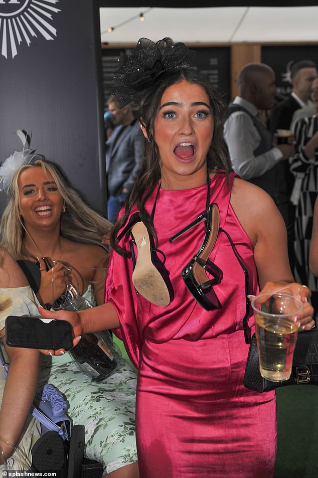 A reveller is pictured wearing her strappy heels not on her feet, but rather around her neck