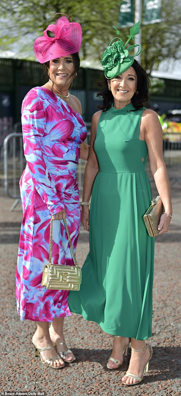 Two women are pictured at the event in Liverpool today, one of them opted to dress in a green frock and the other chose a more colourful look, dressing in blue and pink patterns