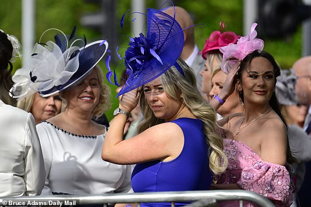A group of women are pictured with large fascinators as they sport bright colours