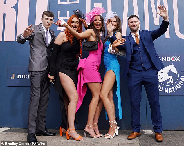 A group of revellers are pictured posing for the cameras in quirky outfits in Liverpool today