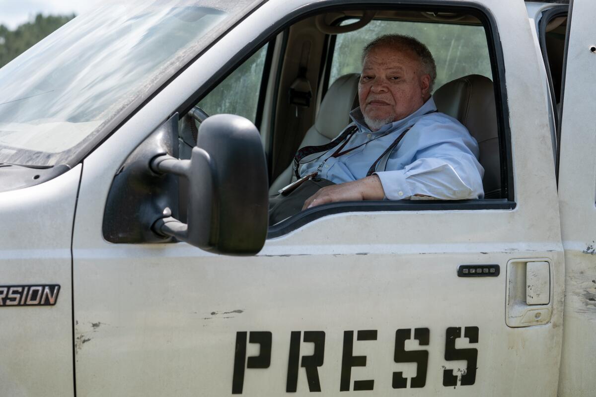 Ein Journalist sitzt am Steuer eines Pressewagens.