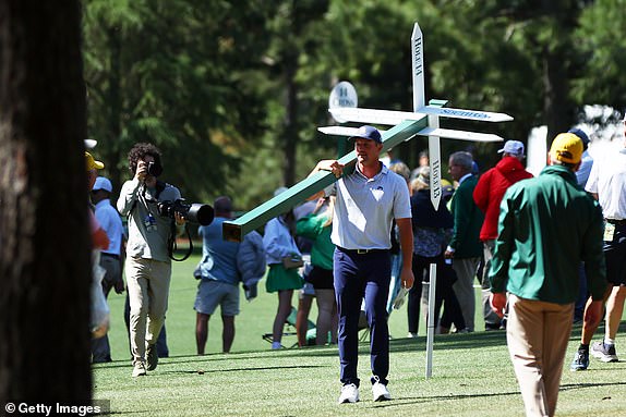 AUGUSTA, GEORGIA - APRIL 12: Bryson DeChambeau of the United States moves a sign while preparing to play his second shot on the 13th hole from the 14th fairway during the second round of the 2024 Masters Tournament at Augusta National Golf Club on April 12, 2024 in Augusta, Georgia. (Photo by Maddie Meyer/Getty Images)