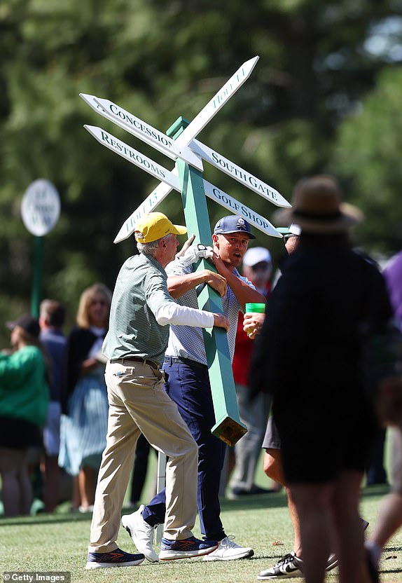 AUGUSTA, GEORGIA - APRIL 12: Bryson DeChambeau of the United States moves a sign while preparing to play his second shot on the 13th hole from the 14th fairway during the second round of the 2024 Masters Tournament at Augusta National Golf Club on April 12, 2024 in Augusta, Georgia. (Photo by Maddie Meyer/Getty Images)