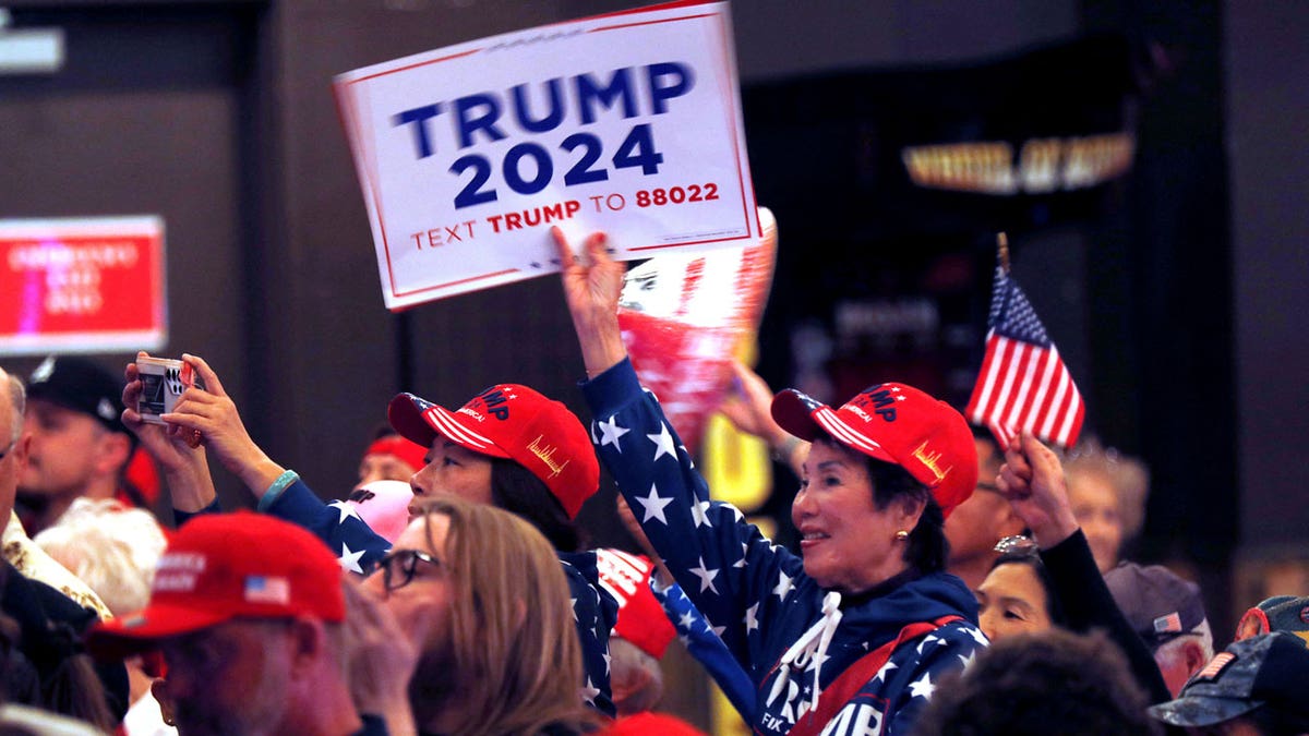 Eine Frau hält einen hoch "Trump 2024" Zeichen