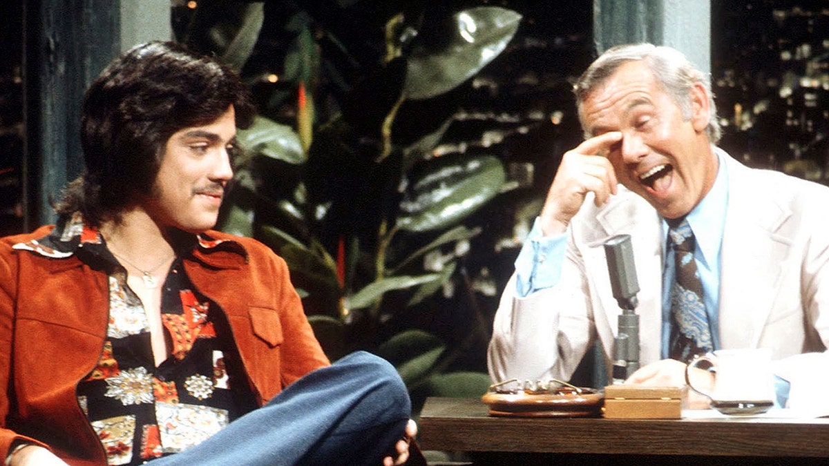 Freddie Prinze sitzt neben einem lachenden Johnny Carson
