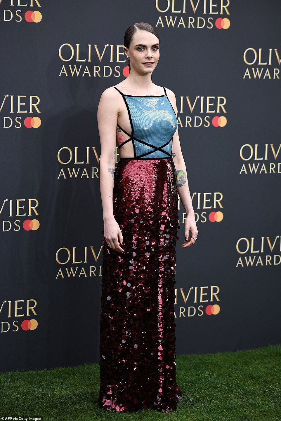 Cara, 31, showed off plenty of skin as she arrived in a show-stopping backless gown, leaving many of her tattoos on full display
