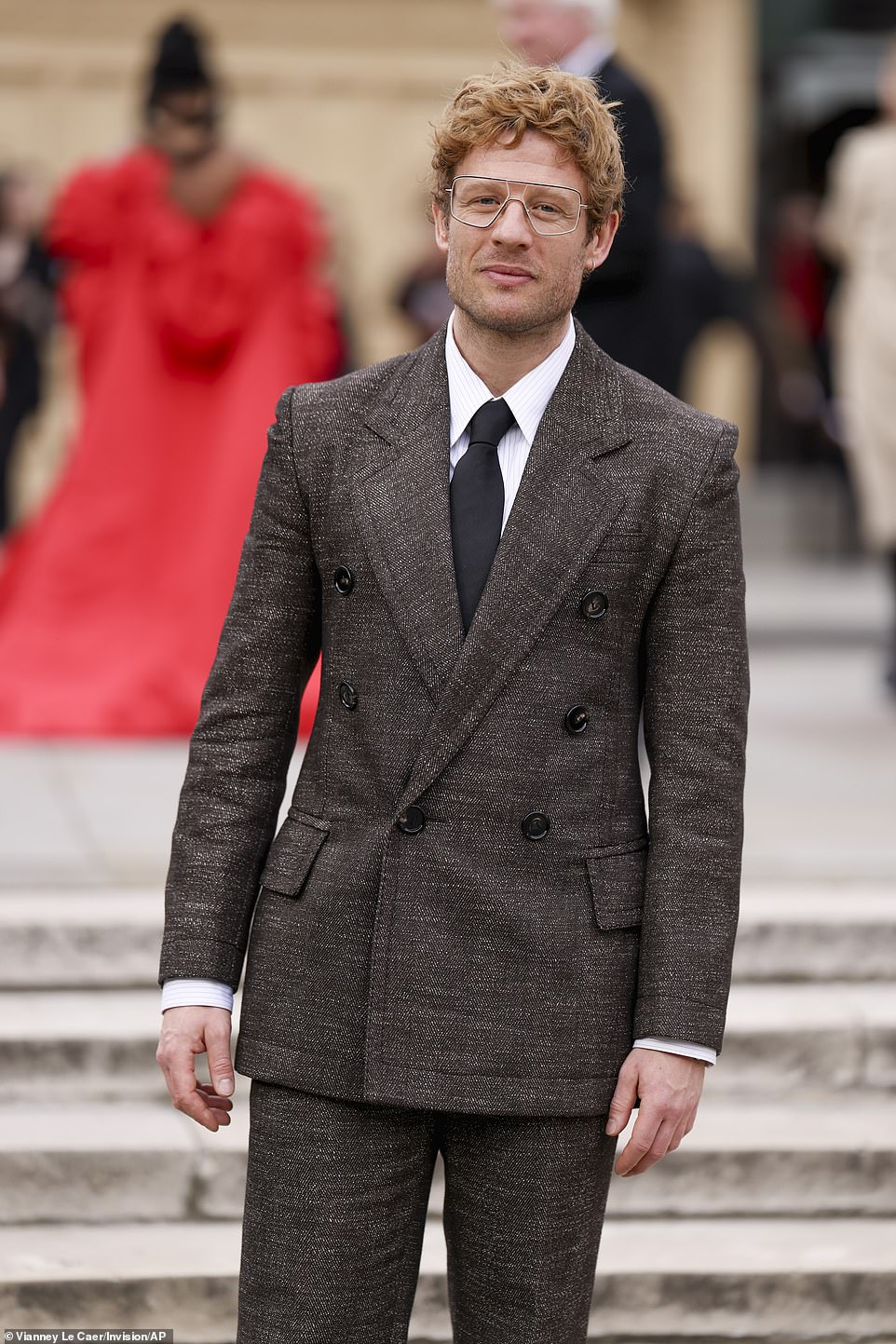 James Norton looked dapper in grey tweed double breasted blazer and trousers, while sporting curly hair and glasses