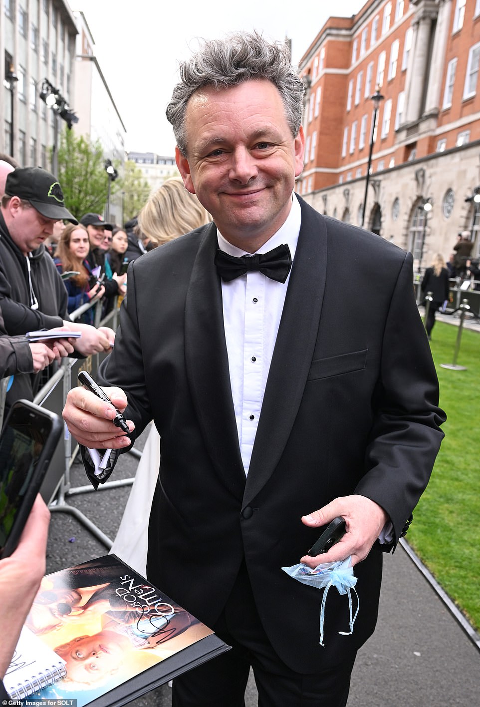 Michael Sheen graciously handed out autographs to the waiting fans as he made his way into the ceremony