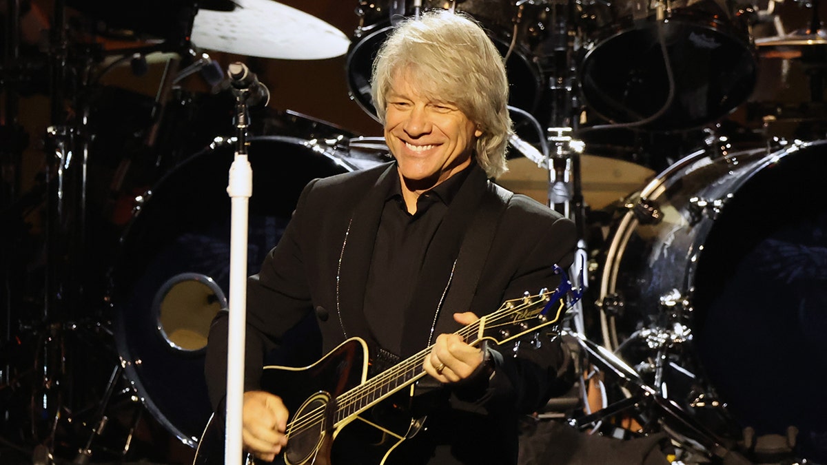 Sänger Jon Bon Jovi spielt Gitarre auf der Bühne