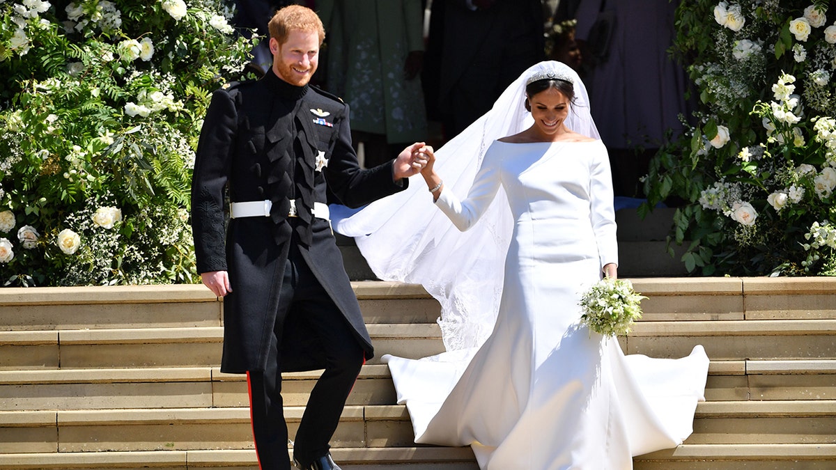 Prinz Harry hält Meghan Markles Hand, als sie die Treppe zur Georges-Kapelle hinuntergehen, wo sie gerade auf Schloss Windsor geheiratet haben