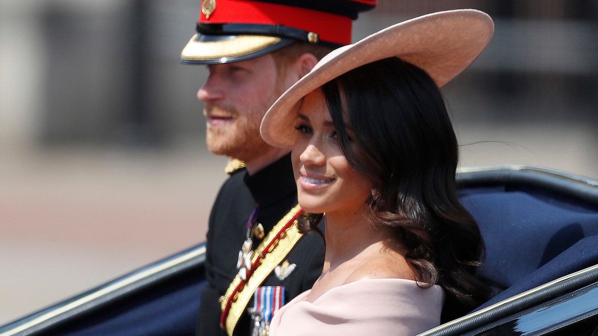 Der britische Prinz Harry (links) und Meghan, Herzogin von Sussex, fahren in einer Kutsche zur jährlichen Trooping the Colour-Zeremonie in London, Samstag, 9. Juni 2018.