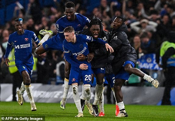 Chelsea's English midfielder #20 Cole Palmer (C) celebrates with teammates after scoring the fourth and winning goal of his team during the English Premier League football match between Chelsea and Manchester United at Stamford Bridge in London on April 4, 2024. (Photo by Glyn KIRK / AFP) / RESTRICTED TO EDITORIAL USE. No use with unauthorized audio, video, data, fixture lists, club/league logos or 'live' services. Online in-match use limited to 120 images. An additional 40 images may be used in extra time. No video emulation. Social media in-match use limited to 120 images. An additional 40 images may be used in extra time. No use in betting publications, games or single club/league/player publications. /  (Photo by GLYN KIRK/AFP via Getty Images)