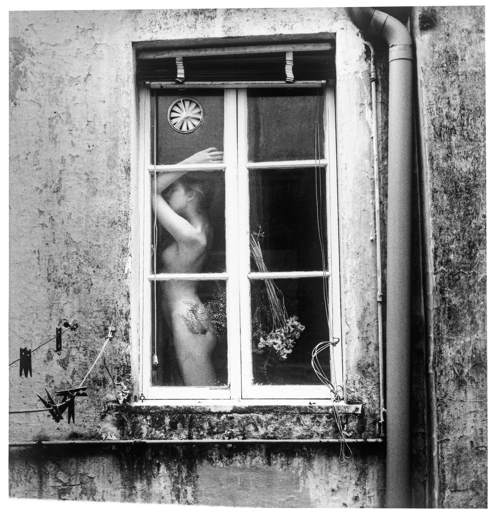 Eine nackte Frau in einem Fenster.