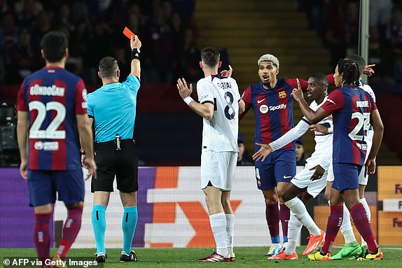 Romanian referee Istvan Kovacs gives a red card to Barcelona's Uruguayan defender #04 Ronald Araujo during the UEFA Champions League quarter-final second leg football match between FC Barcelona and Paris SG at the Estadi Olimpic Lluis Companys in Barcelona on April 16, 2024. (Photo by FRANCK FIFE / AFP) (Photo by FRANCK FIFE/AFP via Getty Images)