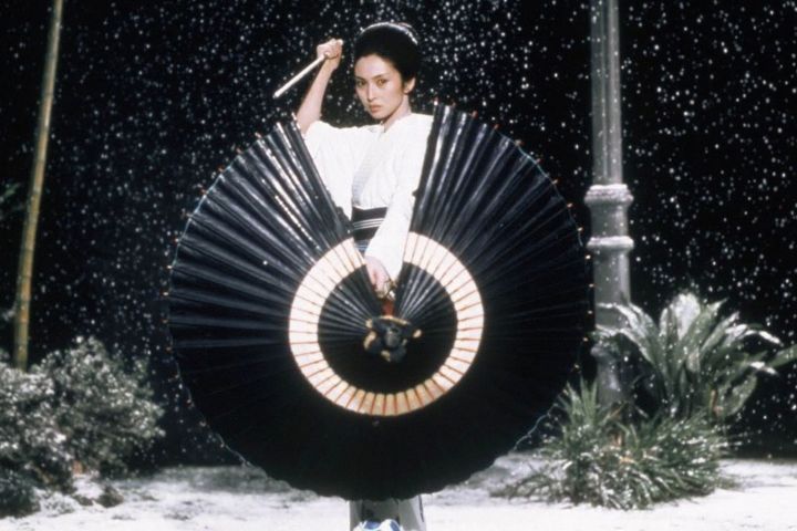 Meiko Kaji hält ein Messer und einen Regenschirm in Lady Snowblood.