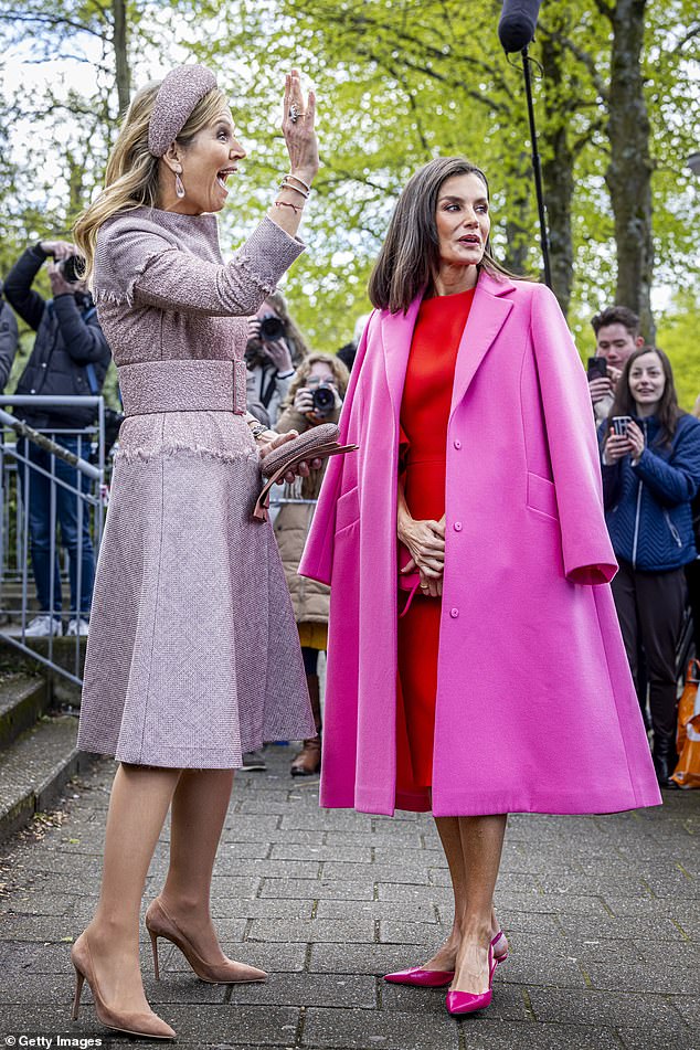 Königin Maxima winkt jemandem aufgeregt zu, während Letizia für die Kameras posiert