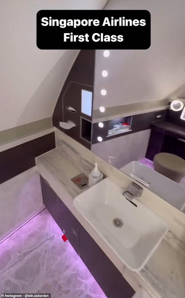 Im privaten Badezimmer sorgt eine rosafarbene LED-Streifenbeleuchtung für Atmosphäre, während über dem Waschbecken ein Hollywood-Kosmetikspiegel hängt und auf einem Regal eine Reihe von Toilettenartikeln platziert sind