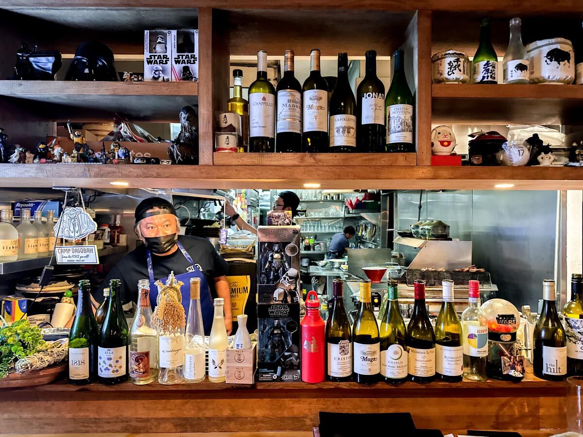 Wein- und Sakeflaschen säumen das Küchenfenster von Hiro Chiyas Hakata Izakaya Hero in Westwood