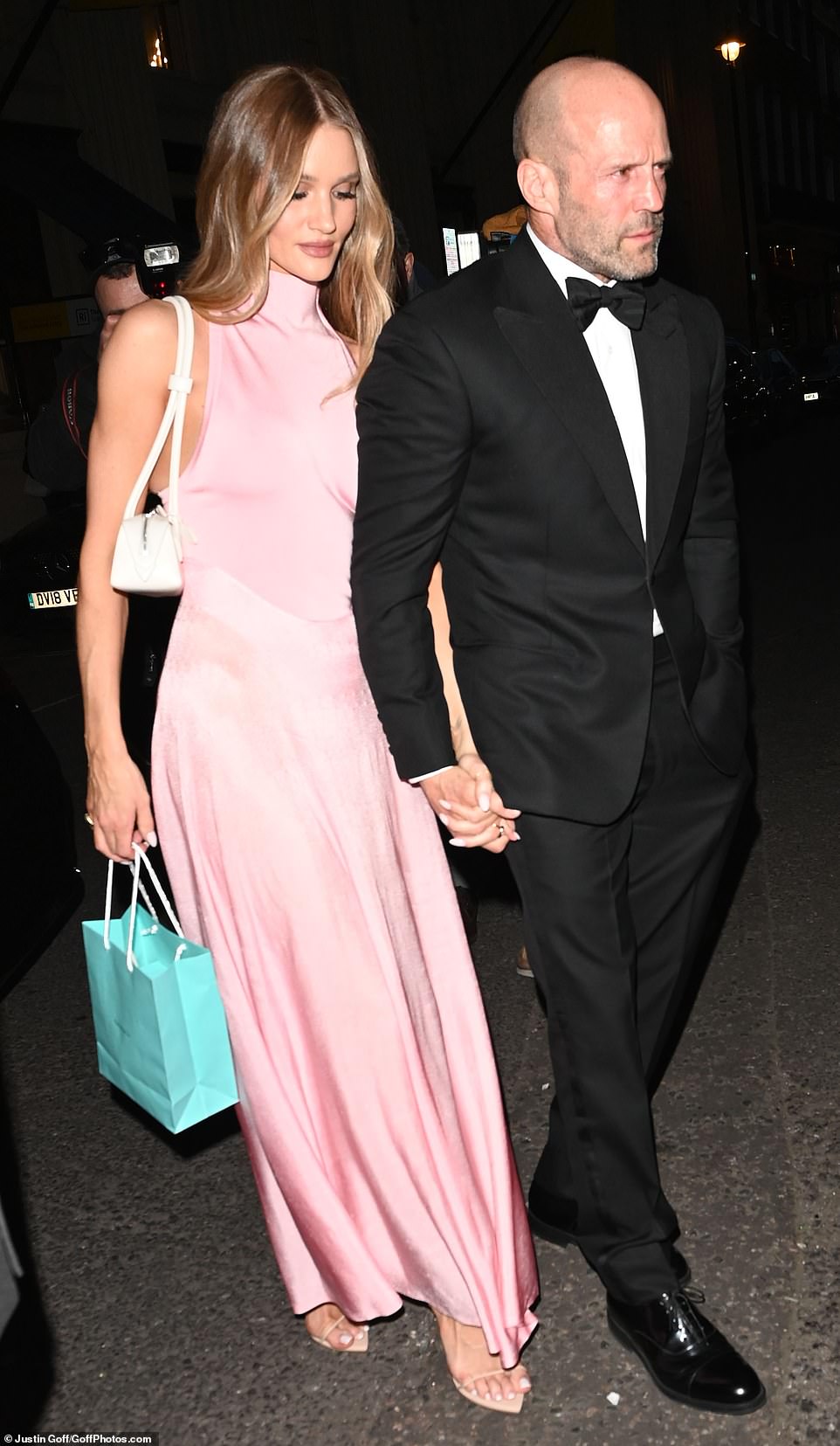 Rosie Huntington-Whiteley cut a glamorous figure in a silky pink gown as she arrived with dashing partner Jason Statham
