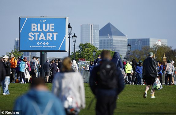 Athletics - London Marathon - London, Britain - April 21, 2024  Participants and spectators at the blue start as Canary Wharf is seen from Blackheath REUTERS/John Sibley